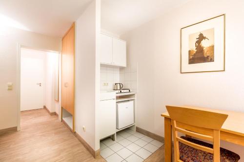 a small kitchen with a table in a room at Hotel am Rokokogarten in Veitshöchheim
