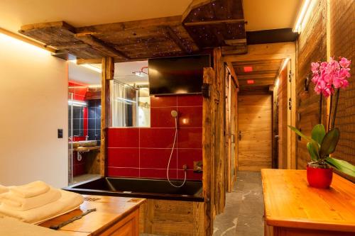 a bathroom with a sink and a red wall at Schnapskeller in Zermatt