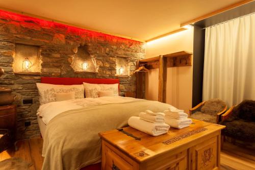 a bedroom with a large bed and a stone wall at Schnapskeller in Zermatt