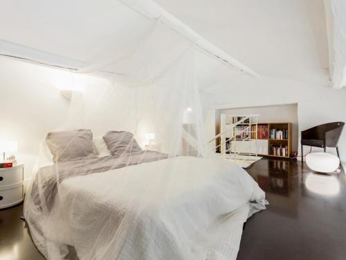 マルセイユにあるWelkeys Apartment - Sainteの白いベッドルーム(ベッド1台、椅子付)
