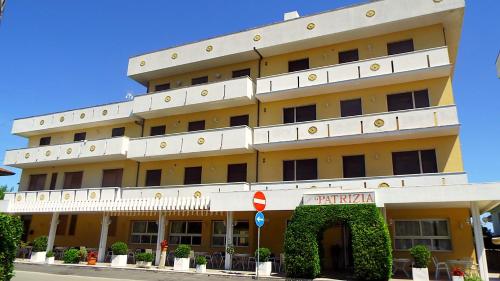 a large yellow building with a sign in front of it at Hotel Patrizia - B&B e Appartamenti in Bellaria-Igea Marina