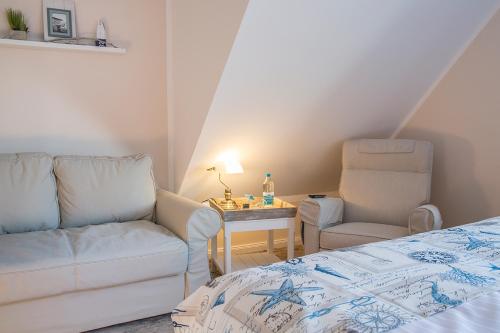 a room with a bed and a couch and a chair at Schmid's Landhaus in Werdum