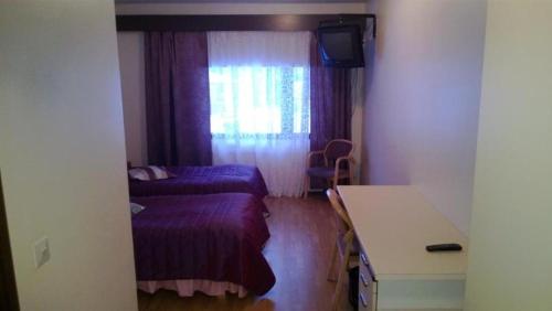 a small room with a bed and a window at Otsolan Hovi in Humppila