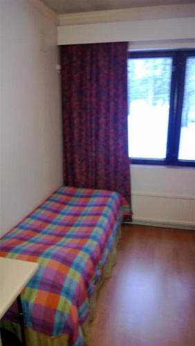 a room with a bed in a room with a window at Otsolan Hovi in Humppila