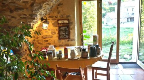 a table and chairs in a room with a window at L'Asphodèle in Venterol