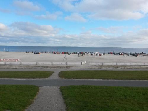 a group of people on a beach near the ocean at Gemütlicher Bungalow in Neuharlingersiel
