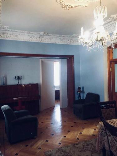 a living room with blue walls and a chandelier at Guesthouse Raisa in Kvareli