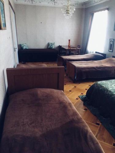 a room with three beds and a couch in it at Guesthouse Raisa in Kvareli