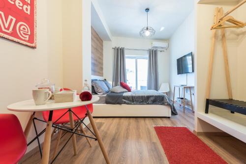- une chambre avec un lit et une table avec une chaise rouge dans l'établissement Athenz Downtown Studio, à Athènes