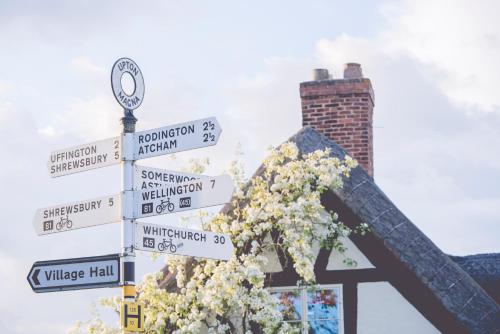 a street sign with many street signs and flowers at The Haughmond in Shrewsbury