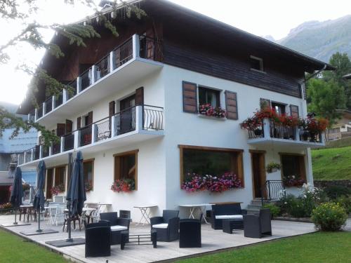 a building with tables and chairs in front of it at Hôtel Flor'Alpes in La Giettaz
