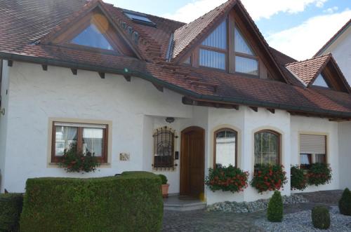 una casa blanca con techo marrón en Privatzimmer Ulbricht/Föhr, en Friedrichshafen