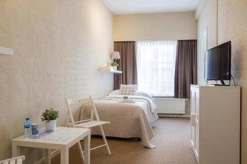 une chambre d'hôtel avec un lit et une télévision dans l'établissement Hotel Franky, à Blankenberge