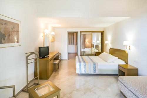 a hotel room with a bed and a television at Iberostar Waves Creta Panorama & Mare in Panormos Rethymno
