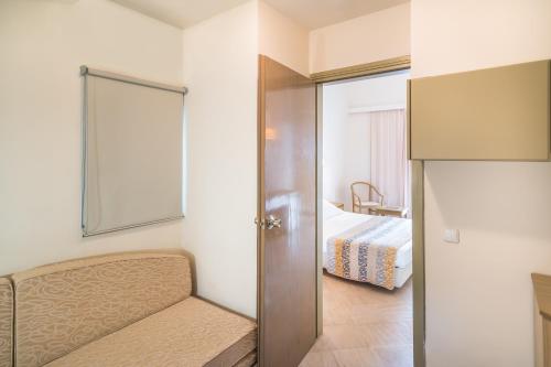 a bedroom with a bed and a sliding glass door at Iberostar Waves Creta Panorama & Mare in Panormos Rethymno