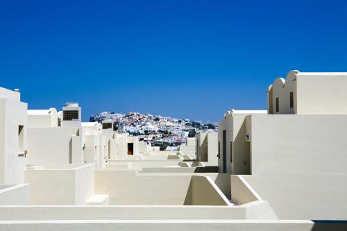 a view of the city from the rooftops of white buildings at The Majestic Hotel in Fira