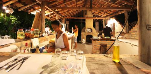 a woman sitting at a table in a restaurant at Pousada Maresia in Atins
