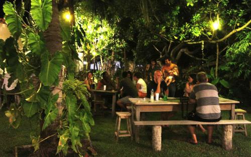 a group of people sitting at tables in a garden at Pousada Maresia in Atins