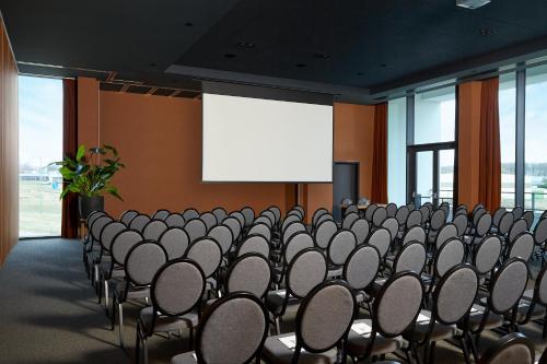 a room with a bunch of chairs and a projection screen at Van Der Valk Luxembourg Arlon in Arlon