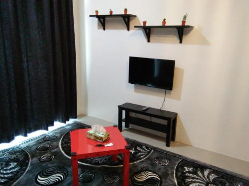 a living room with a tv and a red table at NAUFAL MUSLIM'S HOMESTAY in Cameron Highlands