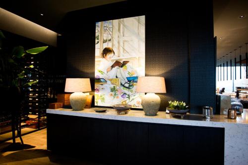 a lobby with two lamps and a painting on the wall at Van Der Valk Luxembourg Arlon in Arlon