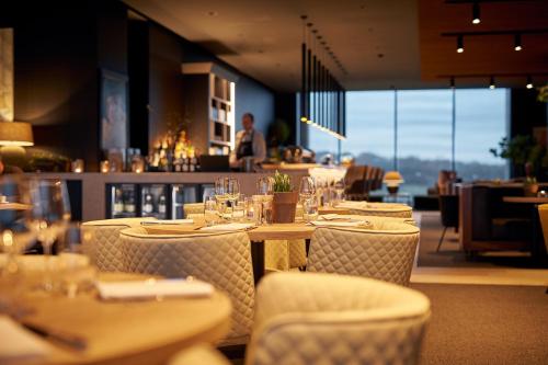 a restaurant with tables and chairs with wine glasses at Van Der Valk Luxembourg Arlon in Arlon