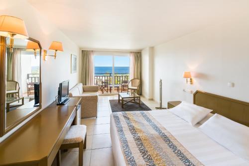 a hotel room with a bed and a view of the ocean at Iberostar Creta Panorama & Mare in Panormos Rethymno