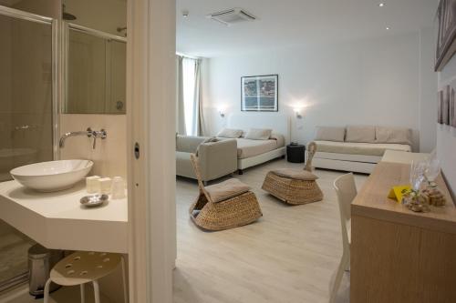 a kitchen and living room with a sink and a bathroom at Hotel Principe in Rimini
