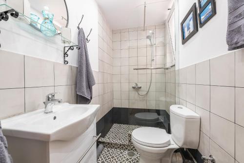 uma casa de banho branca com um lavatório e um WC em Athenz Downtown Studio em Atenas