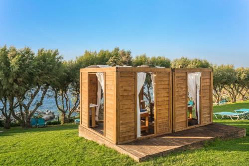 a wooden cabin in the grass in a park at Iberostar Waves Creta Panorama & Mare in Panormos Rethymno