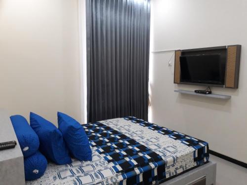 バトゥにあるVilla Beliciaのベッドルーム(青い枕のベッド1台、テレビ付)