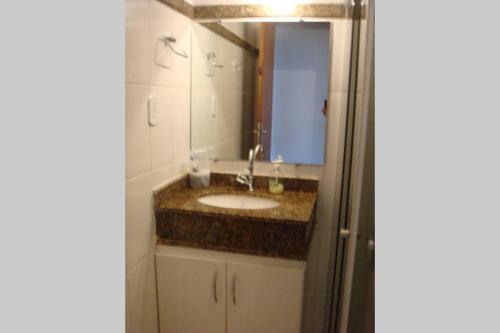 a bathroom with a sink and a mirror at Duplex na beira da praia, de frente pro mar in Salvador