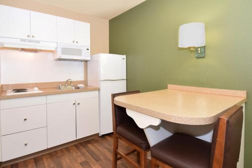 a small kitchen with a table and a refrigerator at Extended Stay America Suites - San Diego - Sorrento Mesa in Sorrento