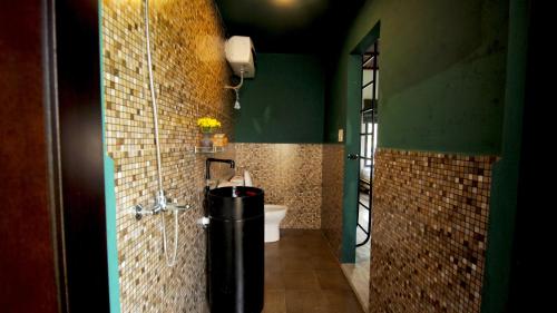 a bathroom with a sink and a toilet in a room at Home Farm Villa Hoi An in Hoi An