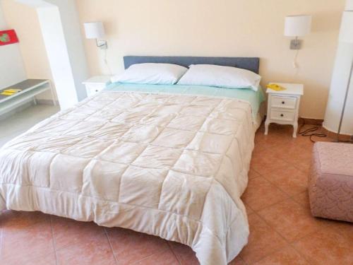 a bedroom with a large bed with a white comforter at Dolce Casa n41 in Savoca 