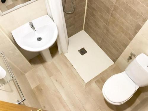 a bathroom with a white sink and a toilet at Hostal Casa Torrent in Canet de Mar