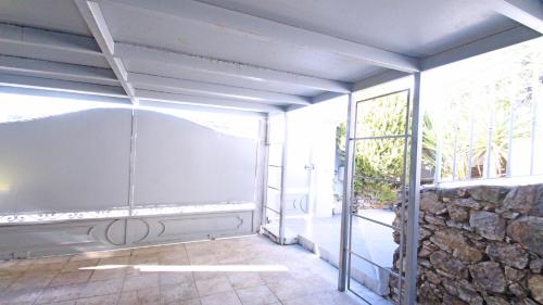 Cette chambre dispose d'une grande fenêtre et d'un mur en pierre. dans l'établissement Villa Jade, à Sainte-Maxime