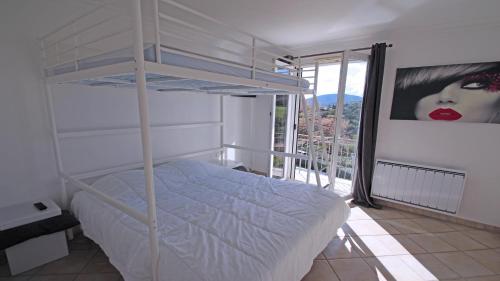 une chambre avec un lit superposé et une grande fenêtre dans l'établissement Villa Jade, à Sainte-Maxime