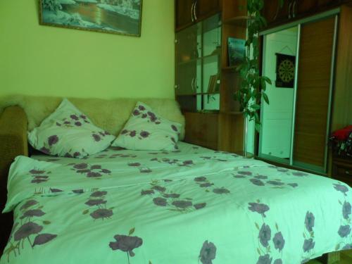 1 dormitorio con 1 cama con colcha de flores en "Ранчо" - тераса квіти сад басейн, en Uzhhorod