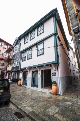 a white building with orange pots in front of it at Miragaia House in Porto