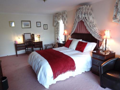 a bedroom with a large bed with a red blanket at Tigh Na Bruach B&B in Invermoriston