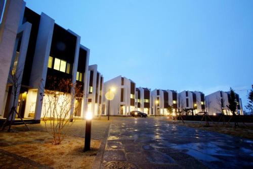 an empty street in front of buildings at night at Farms Village in Jeju