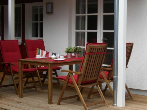 Fewo Kleine Brise Greetsiel في غريتسيل: طاولة وكراسي خشبية على الفناء