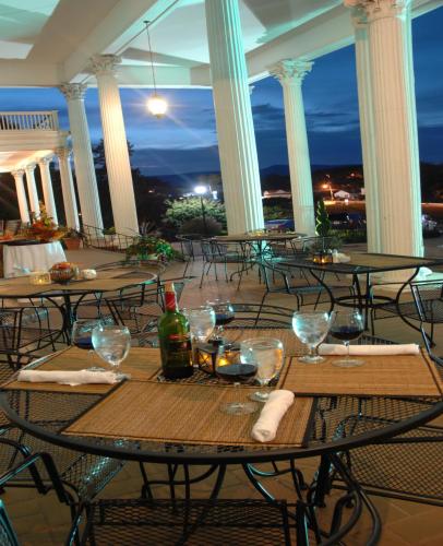 a table with wine glasses on a balcony at night at The Mimslyn Inn in Luray