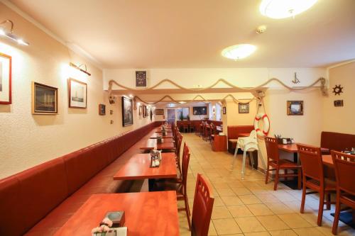 una sala da pranzo con tavoli e sedie in legno di Hotel Atrium Charlottenburg a Berlino