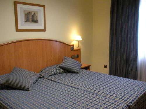 a bedroom with a bed with two pillows on it at II Castillas Madrid in Madrid
