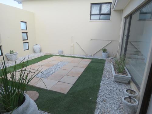 a courtyard with grass and plants in a building at Sea Jewel in Pearly Beach