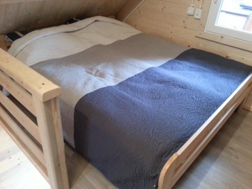małe łóżko w małym pokoju z oknem w obiekcie Domki Finezja w Dziwnówku