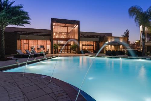 a swimming pool with a large fountain in front of it at Magic Village Yards Trademark Collection by Wyndham in Orlando