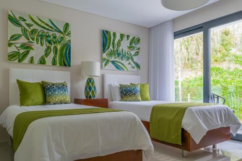 ein Schlafzimmer mit zwei Betten und einem Fenster in der Unterkunft RR House in Ribeira Quente